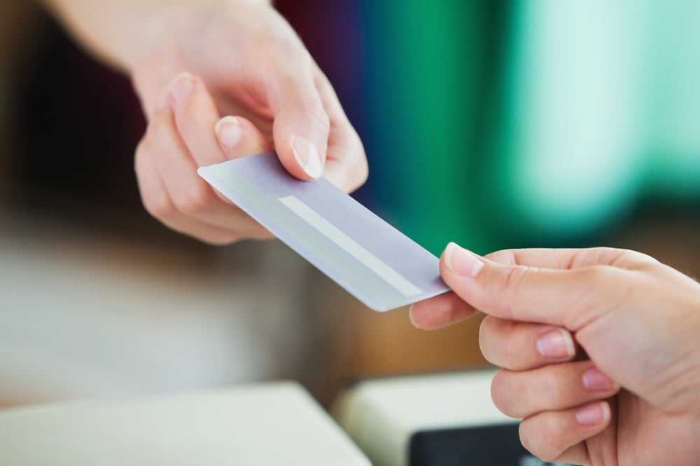 Close-up of a young woman paying with her credit card in a shop