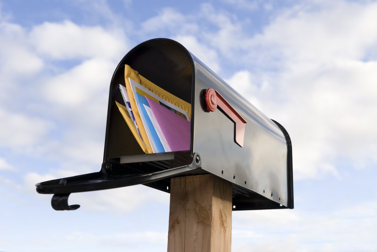 full mailbox against a cloudy sky background